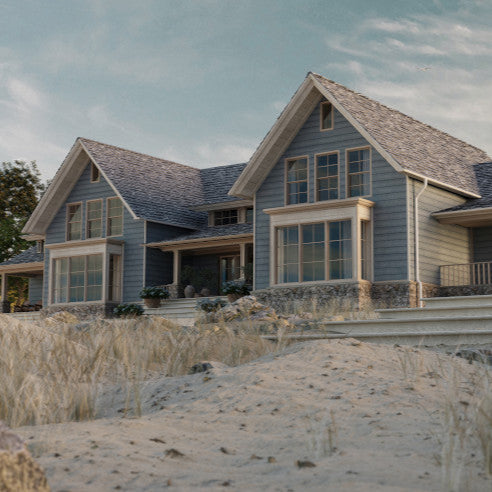 A house with millboard envello siding on a beach front. This house has big open windows with a slightly blue look to it.