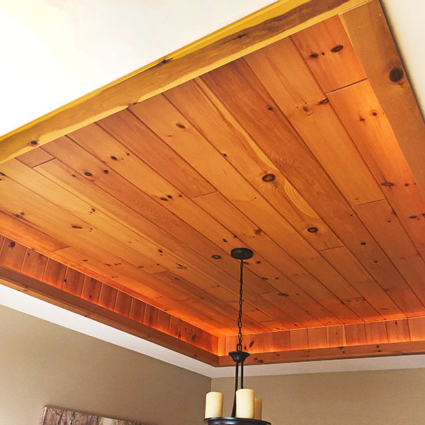 Almond v groove paneling on the ceiling with a light fixture hanging from it.