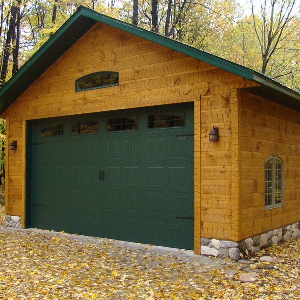 A house with the adaze siding in the woods with a stone basement. 