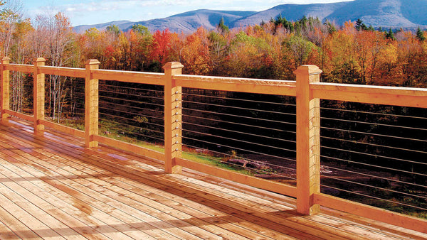 An outdoor deck overlooking the mountains and woods with a custom cable rail system.