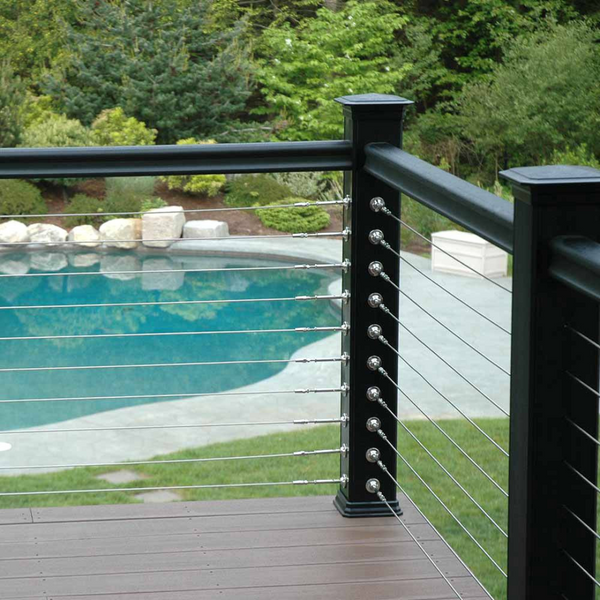 A deck overlooking a pool with a cable rail system.