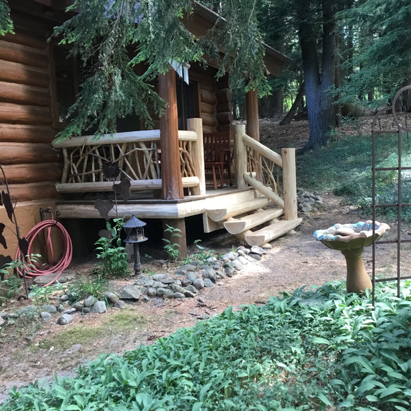 A bright cedar half log staircase enhances the entry way to this rustic cabin.