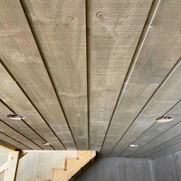A ceiling made out of channel rustic siding.