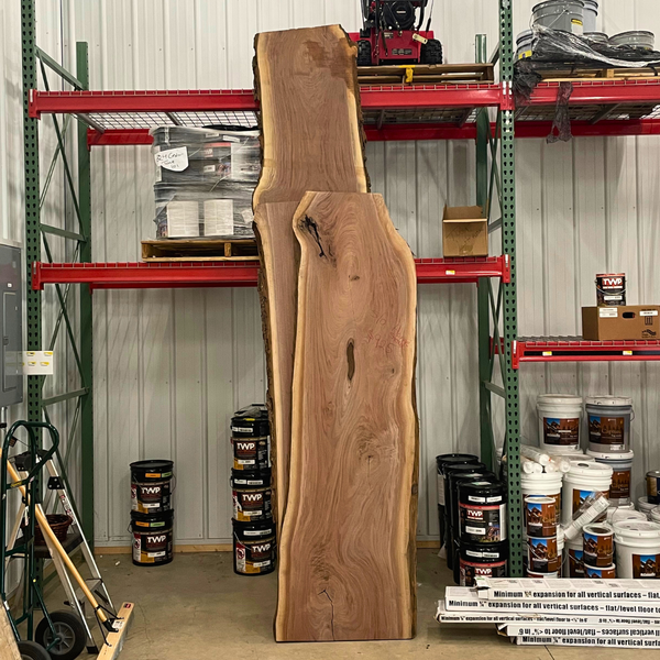 Two large hardwood slabs in a shop leaned up against the shelving. 