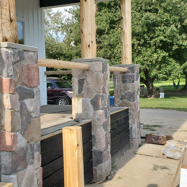 Hollow cedar post wraps are utilized around a porch