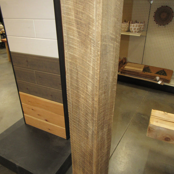 A roughsawn hollow reclaimed beam wrap covers a metal post.