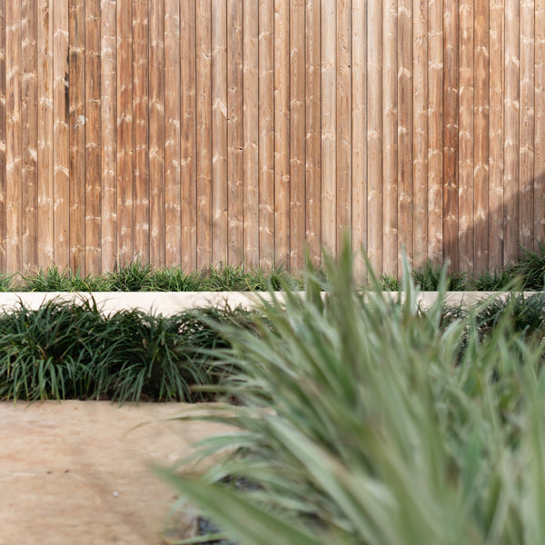 Kebony siding used on a wall with grass displayed around it. 