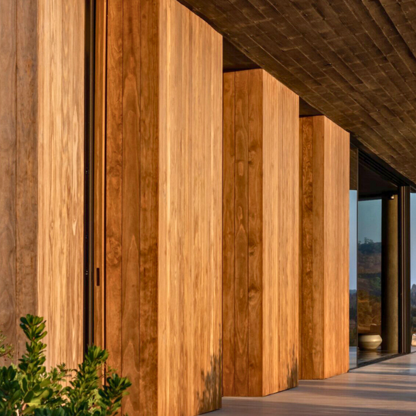 Kebony siding used to complete the side of a house in a very elegant manner. There is a glass window on the end of the house.