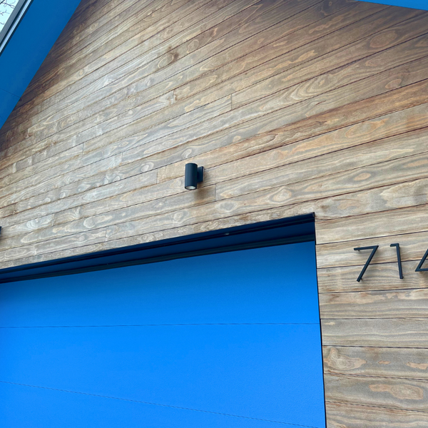 A house close up on a blue garage that is surrounded by Kebony siding.