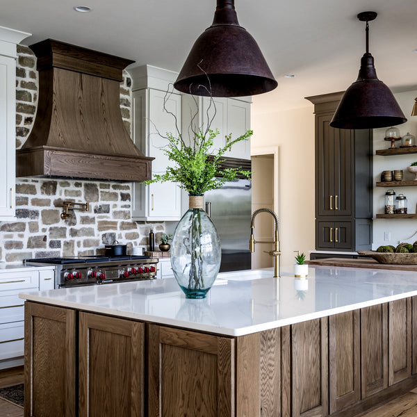 White Kith One Cabinetry in a kitchen with some black and brown Kith One Cabinetry. White countertops and two grey refrigerators. 