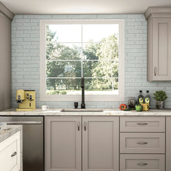 Grey Mantra cabinets in a kitchen with marble countertops.