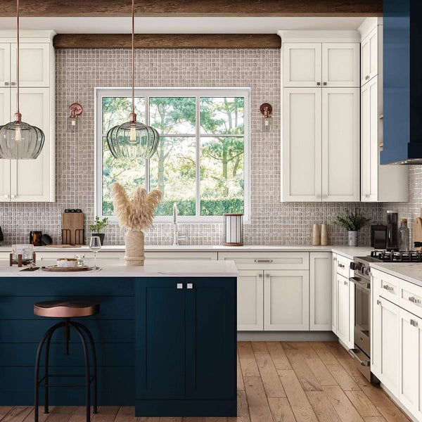 White and blue Mantra Cabinets in a kitchen setting with plants and decor on the countertops.