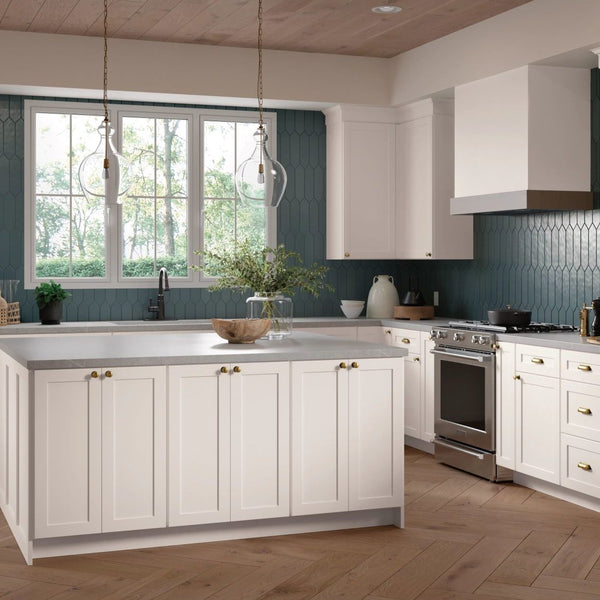 A kitchen setting with white Mantra cabinets. The kitchen has an island in the center of it. 