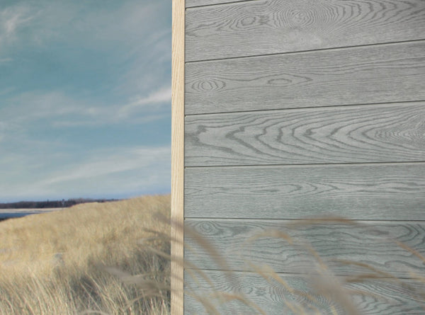 Grey Millboard Envello siding on a house corner on the beach. 