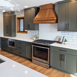 Showplace Cabinets in Moss Green kitchen with wood range hood and white subway tile