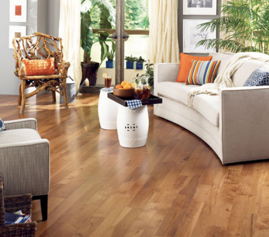 Living room with a white couch and two chairs surround a modern coffee table and all complete the Somerset hardwood flooring. 