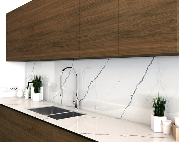 Brown cabinets with Vicostone Quartz countertops in a simplistic kitchen. Plants and decor on the counter with a stainless steel sink.