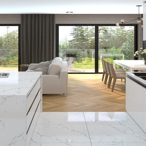 An open kitchen and dining room with Vicostone Quartz countertops. There are flowers on the dining room table and white accents throughout all three areas. 