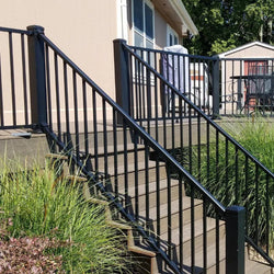 Outside railing with grey steps completed with finished landscape.