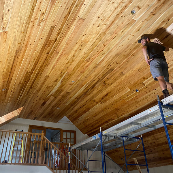 worker installing western red cedar paneling on ceiling