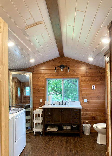 A bathroom created with White Pine T&G Paneling Pre-finished - with bathroom appliances. 