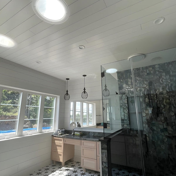 Bathroom completed with a glass shower and white pine tongue and groove walls.