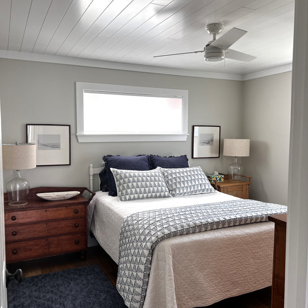 Bedroom with two night stands, a ceiling fan and a blue rug. Completed with a white pine tongue and groove ceiling.
