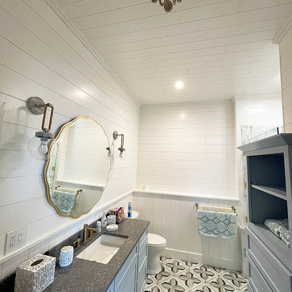 Bathroom with a blue dresser with shelves and a vanity with a grey countertop. Completed with white pine tongue and groove pre-finished walls and ceiling. 
