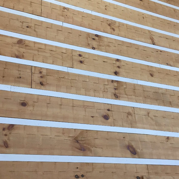 White pine 1x12 adze appalachian siding with painted white chink strip.